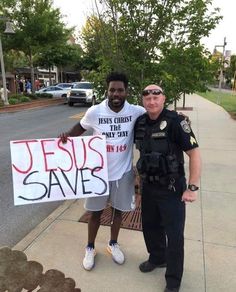 two men standing next to each other holding a sign that says jesus saves on it