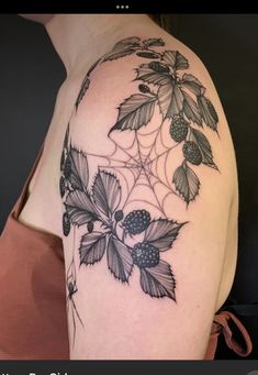 a woman's shoulder with leaves and berries on it