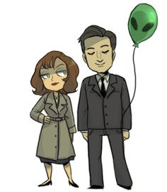 a man and woman standing next to each other with an alien balloon in the air