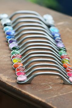 a row of multicolored scissors sitting on top of a wooden table