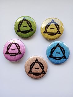 four different colored buttons with symbols on them