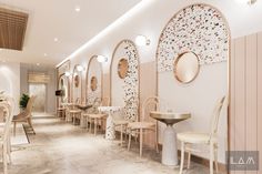 the interior of a restaurant with tables, chairs and mirrors on the wall above them