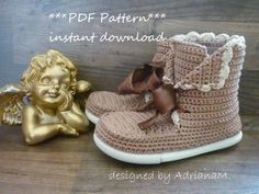 a pair of crocheted baby boots with angel figurines next to them