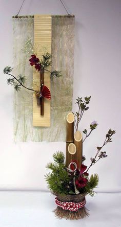 a vase filled with flowers sitting on top of a table next to a wall hanging