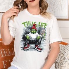 Thug Life Grinchmas Shirt | Funny Christmas Tee | Grinch Lovers Christmas Gift Idea Get into the holiday spirit with a twist of humor with this "Thug Life Grinchmas" shirt! Perfect for fans of the classic Grinch, this funny Christmas tee is great for family gatherings, movie nights, or as a unique Christmas gift idea for Grinch lovers. Spread festive cheer with a dash of attitude and give everyone a laugh this holiday season! Funny Christmas Shirt, Grinch Christmas Gift, Thug Life Grinch 🌟 How to Order:  1️⃣ Check all photos carefully. 2️⃣ Select your t-shirt size and color. Note: Slight color variations may occur due to different brands. For exact color matching, choose the same style (e.g., Unisex, V-necks, Toddler). 3️⃣ Add to cart, and feel free to add more items. 4️⃣ Proceed to check Family Christmas Movies, Funny Christmas Tshirts, Christmas Tshirt, Funny Christmas Shirts, Christmas Movie, Movie Nights, Grinch Christmas, Thug Life, Unique Christmas Gifts