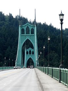 the bridge is very tall and has many lights on each side as well as cars driving across it