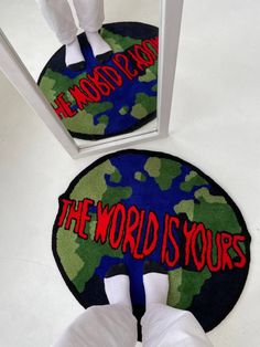 the world is yours door mat in front of a mirror with two hands on it