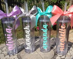 three personalized tumblers with bows on them sitting on top of a stone slab