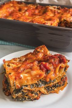 a white plate topped with lasagna casserole next to a baking dish