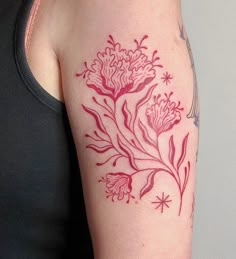 a woman's arm with a red flower tattoo on the left side of her arm