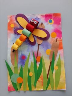 an art project made out of construction paper and cardboard with a dragonfly on it