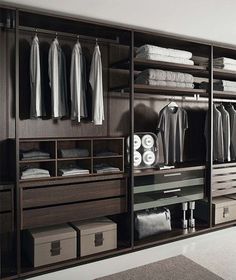 an organized closet with clothes hanging on the wall and drawers in front of each other