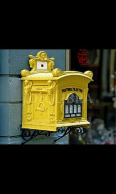 a yellow mailbox attached to the side of a building