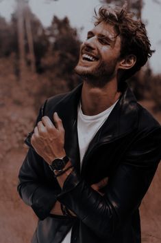 a man laughing while wearing a black leather jacket