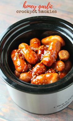 a crock pot filled with meatballs and sauce on top of a wooden table