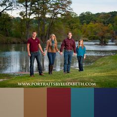 four people holding hands while standing in front of a body of water with trees behind them