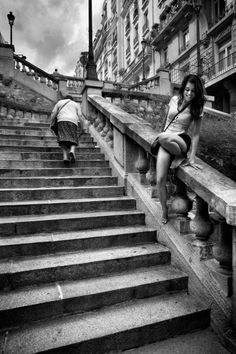 black and white photograph of two women sitting on stairs