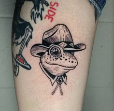 a tattoo on the leg of a person wearing a hat