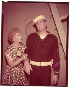 an old photo of a man and woman dressed in sailor attire standing next to each other