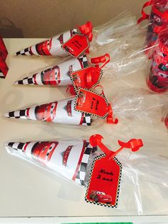 red and white candy cones wrapped in cellophane are sitting on a table next to each other