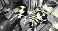 two dolls are laying on the floor next to suitcases and other items in black and white