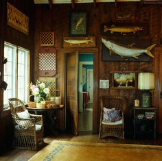 a living room filled with furniture and paintings on the wall above it's doorway