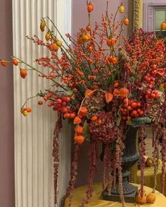 a vase filled with lots of red flowers on top of a yellow cloth covered table