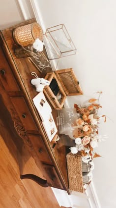 a wooden dresser with baskets and flowers on it