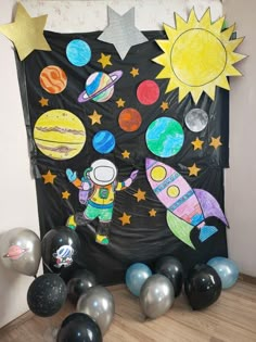 a space themed bulletin board surrounded by balloons