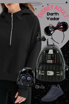 a woman in black hoodie and darth vader backpack with star wars items