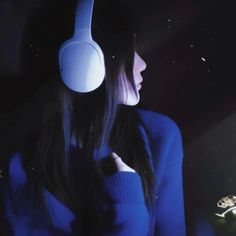 a woman wearing headphones in the dark