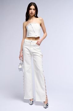 Iced out. The AKIRA Label Covered In Diamonds Relaxed Jeans In White feature a semi-stretchy cotton denim fabrication, a high rise waist, functional belt loops, a classic five-pocket design, tonal stitching, faux silver metallic hardware, and a relaxed, wide-leg silhouette with distressed fringe hems. Complete with long, sexy side slits, adorned with rhinestone gem link detailing, and a front zip button closure. Pair with a cropped tank and PVC heels for a finished look.   - 98% Cotton 2% Spandex - Semi-Stretchy - Imported  (all measurements are approximate from size 3) - 11” Rise - 32.25” Inseam - Model is 5’9” Product ID: 382918  (all measurements are approximate from size 19) - 13.5” Rise - 32.75” Inseam Product ID: 382926 Pvc Heels, Relaxed Jeans, Crop Tank, Pocket Design, Metallic Silver, Wide Leg, High Rise, Fabric, White