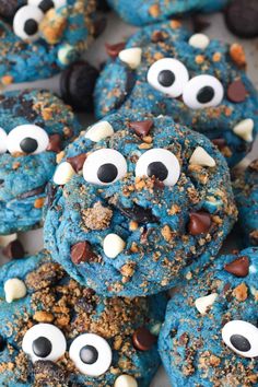 blue monster cookies with googly eyes and chocolate chips in the shape of monsters on top