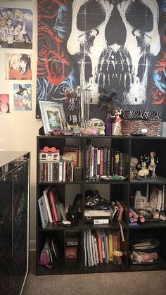 a bookshelf filled with lots of books next to a wall covered in skulls