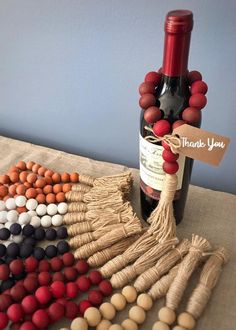 a bottle of wine sitting on top of a table next to some beads and string