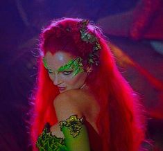 a woman with red hair and green makeup