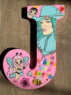 the letter j is painted with pictures of cartoon characters and letters on pink wood planks