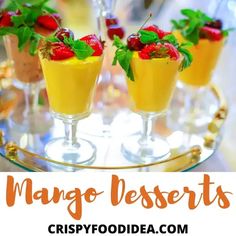 mango desserts with strawberries and mint garnish on a gold platter