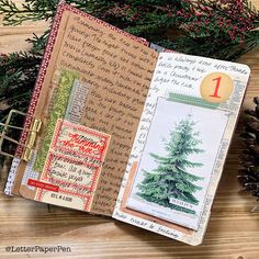 an open journal with christmas cards and pine cones