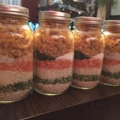 four jars filled with food sitting on top of a table