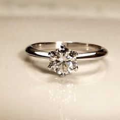 a white diamond ring sitting on top of a table