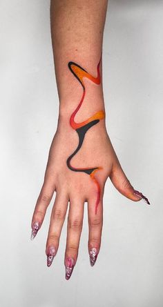 a woman's hand with an orange and black design on it