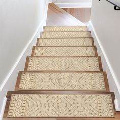 a set of stairs leading up to an upstairs hallway with carpeted flooring and wooden handrails