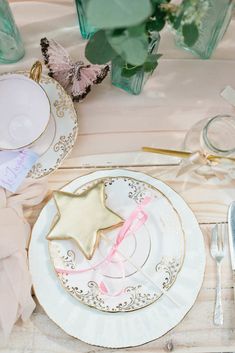 a table set with plates, silverware and napkins