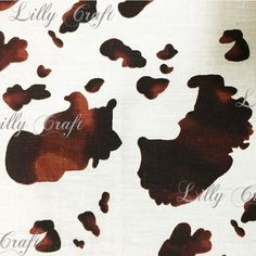 an animal print on white fabric with brown spots and black spots in the center,