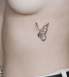 a woman's stomach with a small butterfly tattoo on her left side ribcage