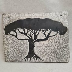 a black and white tile with a tree on it