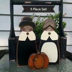 two wooden penguins sitting next to each other in front of a sign that says 3 piece set