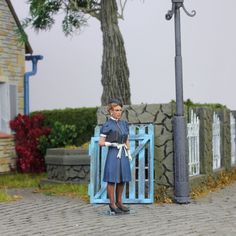 a woman standing in front of a blue gate