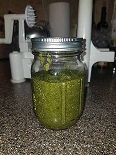 a jar filled with green liquid sitting on top of a counter